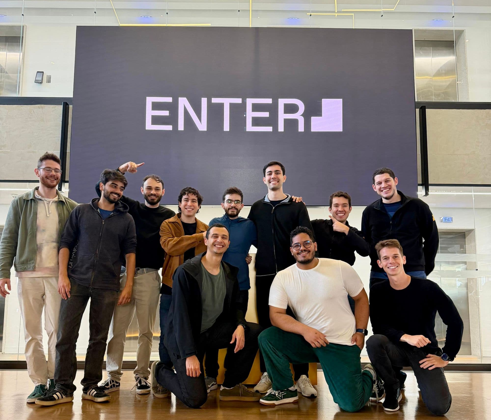 Me with my Enter AI Fellowship cohort in front of the Enter logo